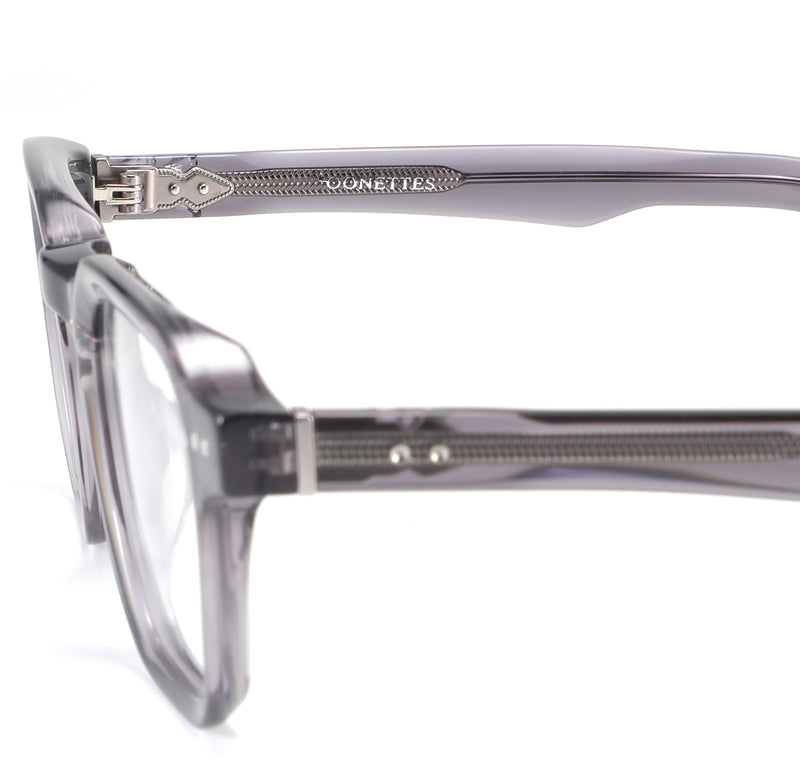 Close-up of a pair of eyeglasses with a clear frame on a white background